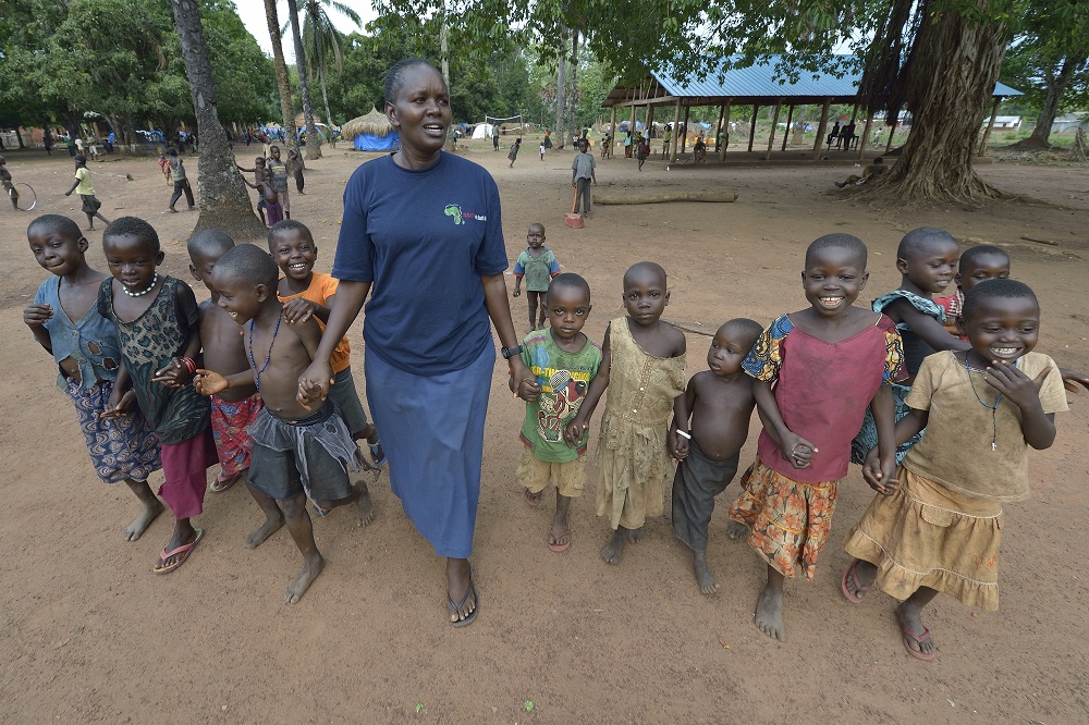 Sr. Josephine Murigi, a member of Our Lady of the Missions and Solidarity with South Sudan, walks with children in a camp for more than 5,000 displaced people in Riimenze in June 2017. Families were displaced in late 2016 and early 2017 as fighting betwee