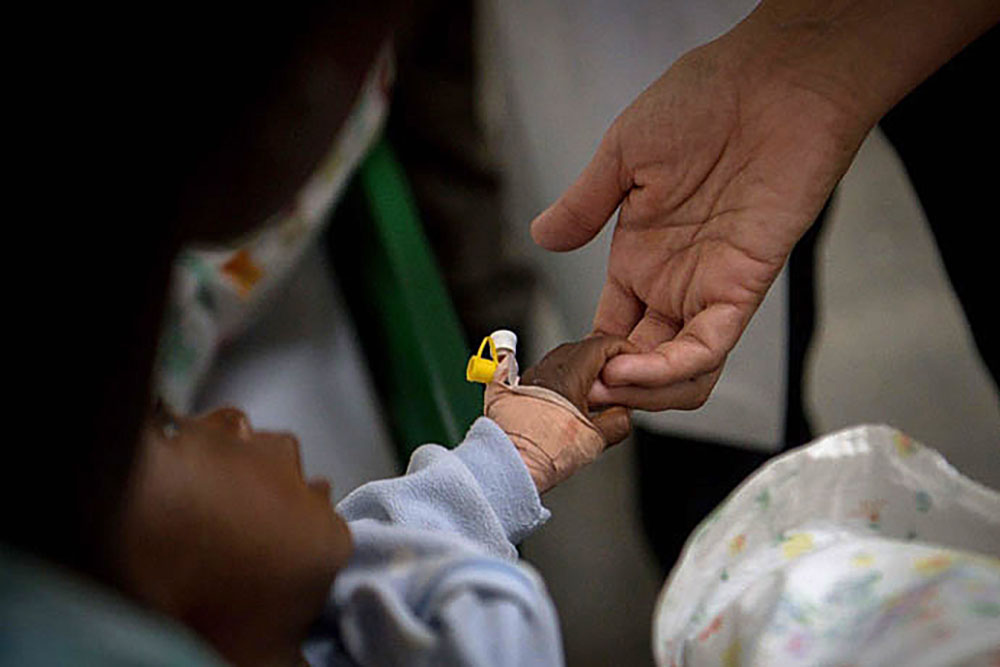 An Ursuline sister holds the hand of an infant patient in a cholera clinic in Verrettes, Haiti, in 2017. (CNS/Journey Press/Bryan Woolston) An Ursuline sister holds the hand of an infant patient in a cholera clinic in Verrettes, Haiti, in 2017. (CNS/Journey Press/Bryan Woolston)