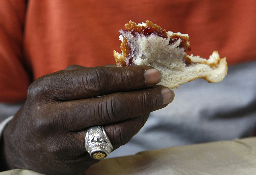 A man eats a sandwich at a soup kitchen in this 2016 file photo. (CNS/Karen Pulfer Focht)