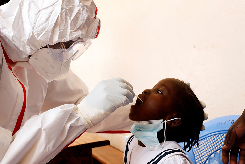 A health care worker takes a swab from a child during a mass testing May 26 in Nairobi, Kenya, during the COVID-19 pandemic. (CNS/Baz Ratner, Reuters)