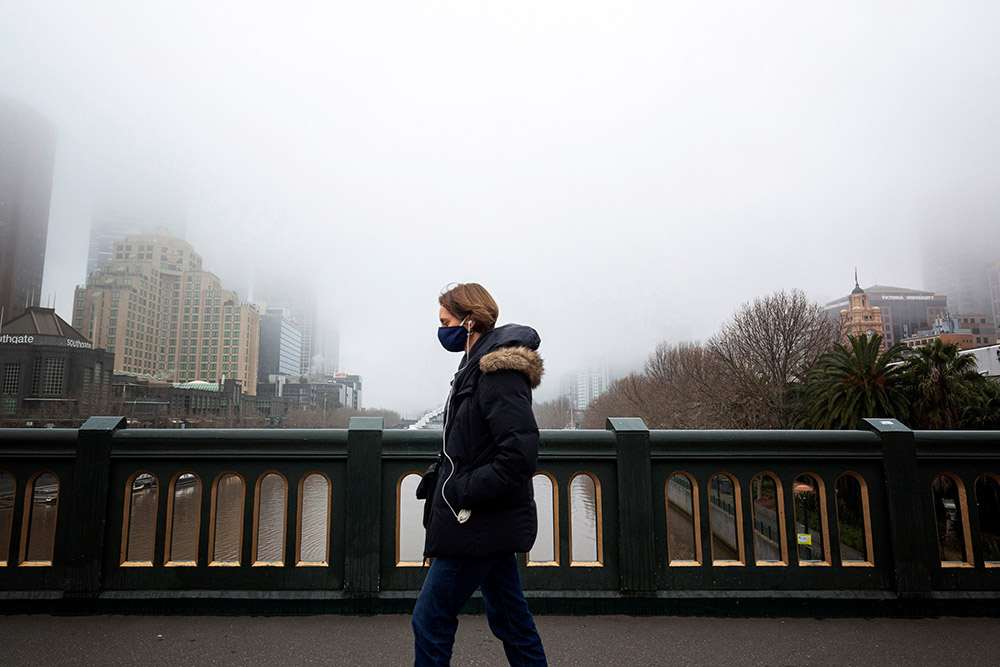 A person in a protective face mask walks along the Princes Bridge in Melbourne, Australia, July 17, 2020, during a lockdown in response to the coronavirus pandemic. (CNS/Reuters/Daniel Pockett)