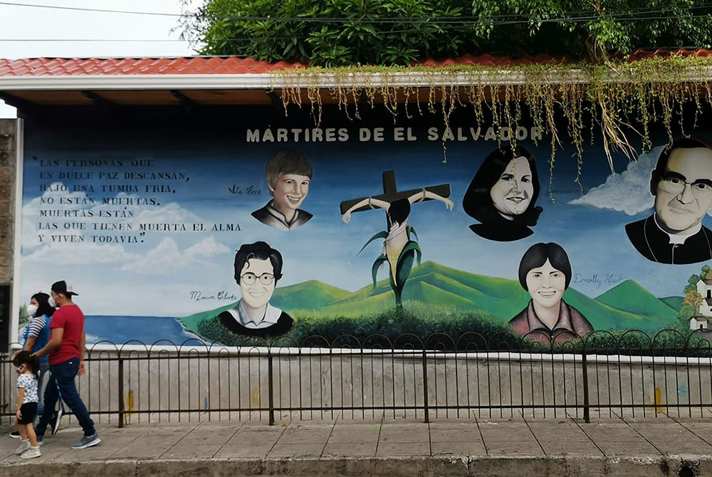 Salvadorans walk past a mural of Salvadoran martyrs Aug. 15, outside Our Lady of Pilar Catholic Church in Zaragoza, El Salvador. (CNS/Courtesy of Patricia Lazo)