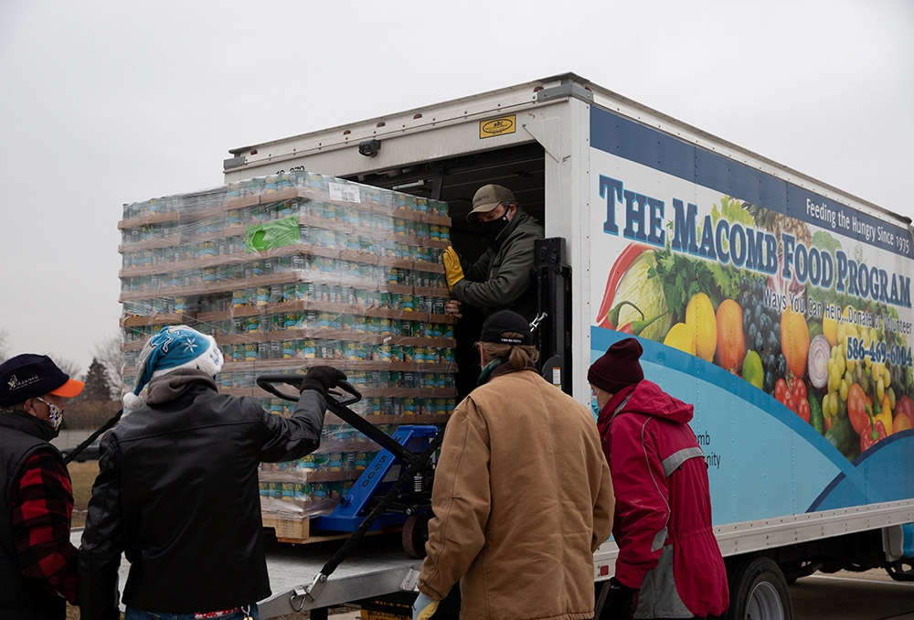 Volunteers from Forgotten Harvest food bank in Warren, Michigan, unload goods before a mobile food pantry distribution Dec. 21, 2020, amid the coronavirus pandemic. (CNS/Reuters/Emily Elconin)
