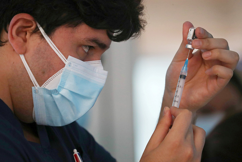 A health care worker at the Posta Central Hospital in Santiago, Chile, prepares a dose of the Pfizer/BioNtech COVID-19 vaccine Dec. 24 amid the coronavirus pandemic. (CNS/Reuters/Ivan Alvarado)
