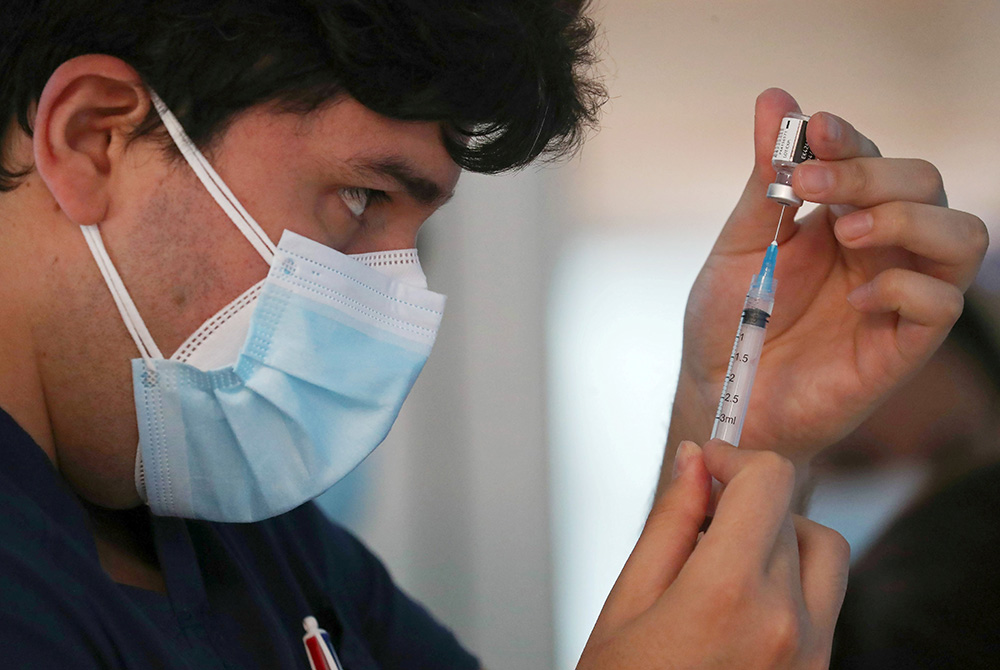 A health care worker at the Posta Central Hospital in Santiago, Chile, prepares a dose of the Pfizer/BioNtech COVID-19 vaccine Dec. 24 amid the coronavirus pandemic. (CNS/Reuters/Ivan Alvarado)