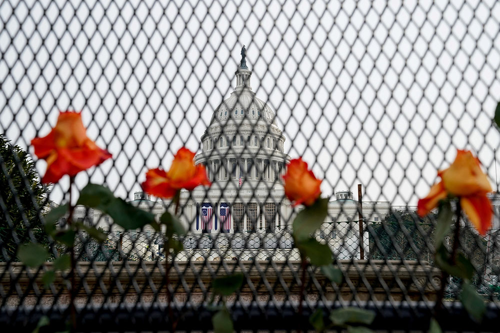 Flowers are placed in security fencing around the U.S. Capitol in Washington Jan. 11, days after supporters of President Donald Trump stormed the building. (CNS/Reuters/Erin Scott)