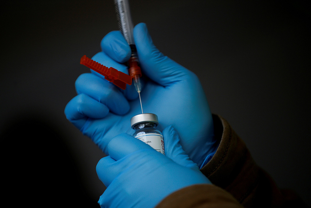A health care worker in Sequim, Washington, draws a dose of the Moderna COVID-19 vaccine from a vial in this illustration photo. (CNS/Reuters/Lindsey Wasson)
