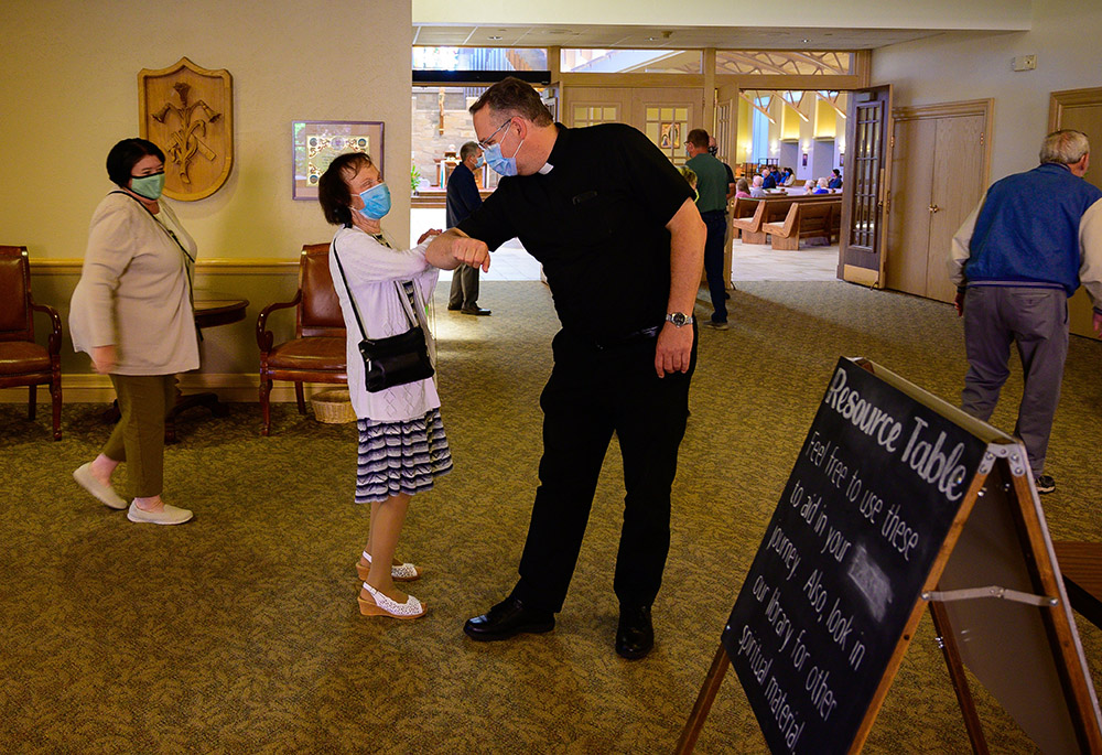 Fr. Peter Ambting, pastor of Our Lady of Lourdes Parish in De Pere, Wisconsin, greets a parishioner before Mass in this June 14, 2020, file photo. (CNS/The Compass/Sam Lucero)