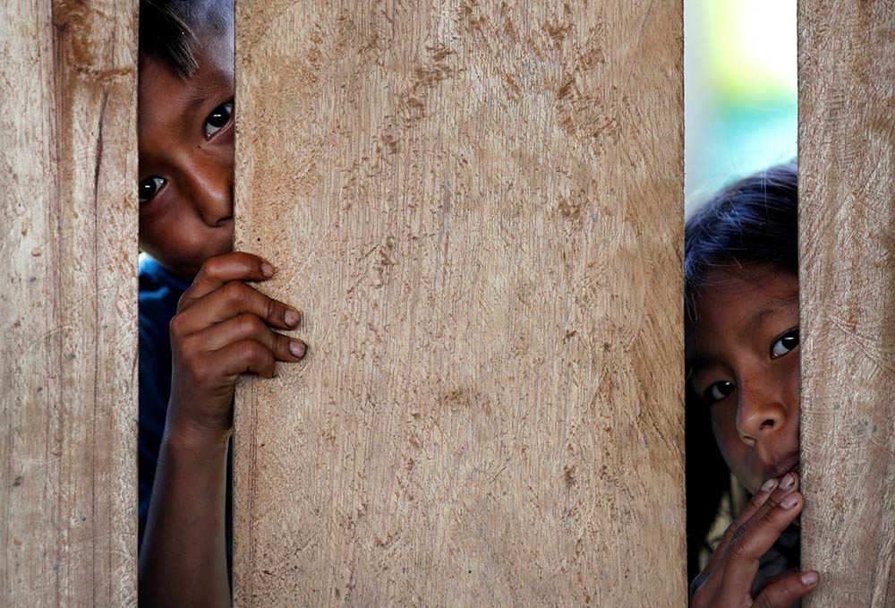 Children look on as relatives receive the Sinovac COVID-19 vaccine March 3 in São Gabriel da Cachoeira, Brazil. (CNS/Reuters/Ueslei Marcelino)