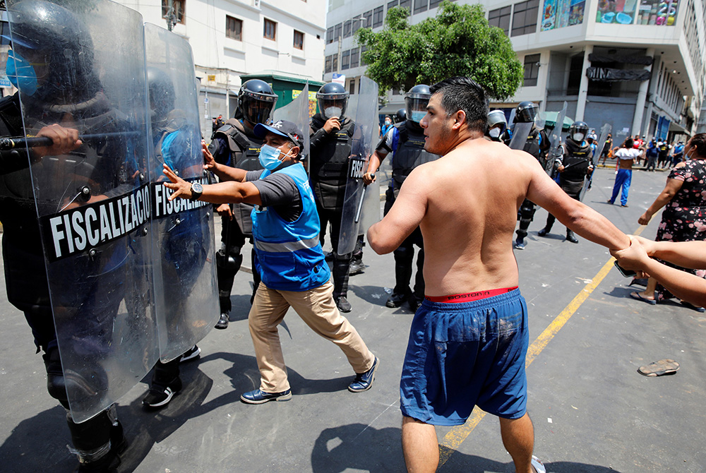 Protesters and street vendors argue with riot police over new government restrictions Feb. 1 in Lima, Peru. (CNS/Reuters/Sebastian Castaneda) 