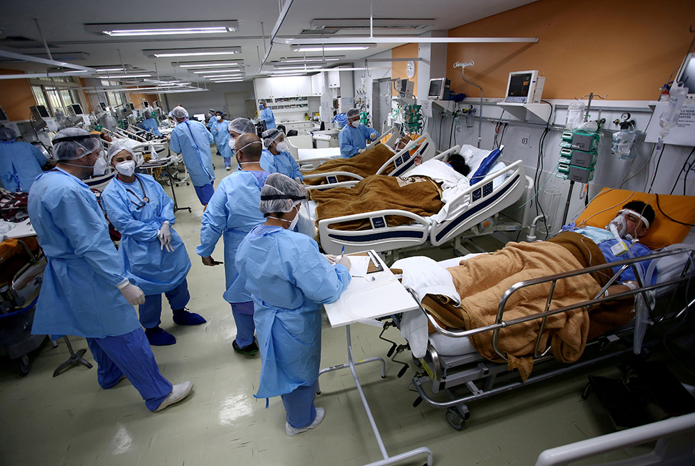 Medical workers take care of patients in the emergency room of the Nossa Senhora da Conceicao hospital March 11 in Porto Alegre, Brazil. (CNS/Reuters/Diego Vara)