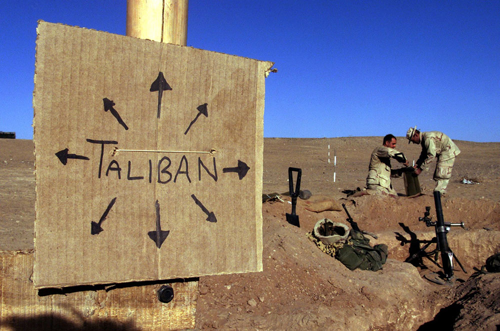 Marines from Charlie 1/1 of the 15th Marine Expeditionary Unit in southern Afghanistan fill sandbags around their light mortar position on the front lines of a Marine Corps base Dec. 1, 2001. (CNS/Reuters/Jim Hollander)