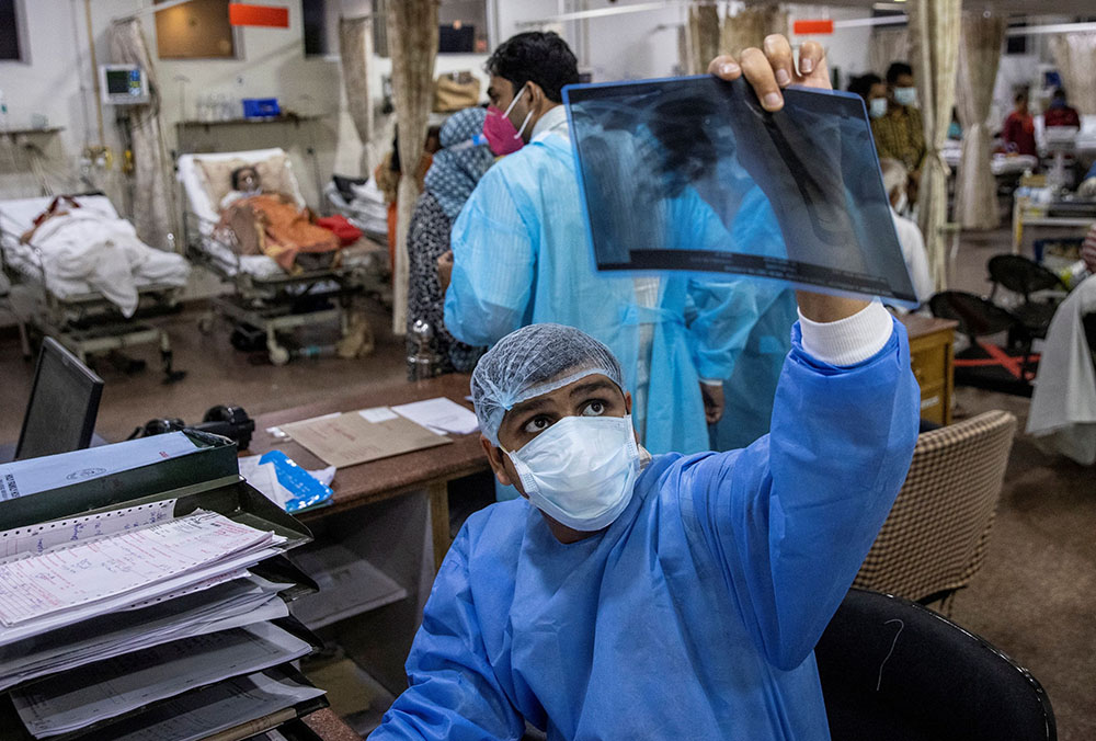 A doctor at Holy Family Hospital in New Delhi looks at a patient's X-ray May 1 amid the coronavirus pandemic. (CNS/Reuters/Danish Siddiqui)