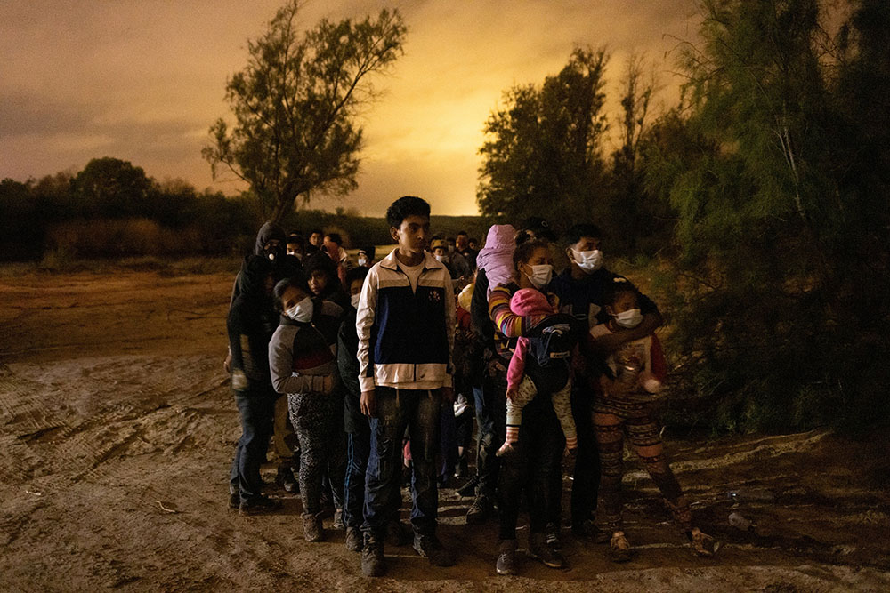 Migrants from Central America seeking asylum in the United States line up May 15 to be escorted to the main road by the Texas Army National Guard in Roma, Texas, after crossing the Rio Grande. (CNS/Reuters/Adrees Latif)