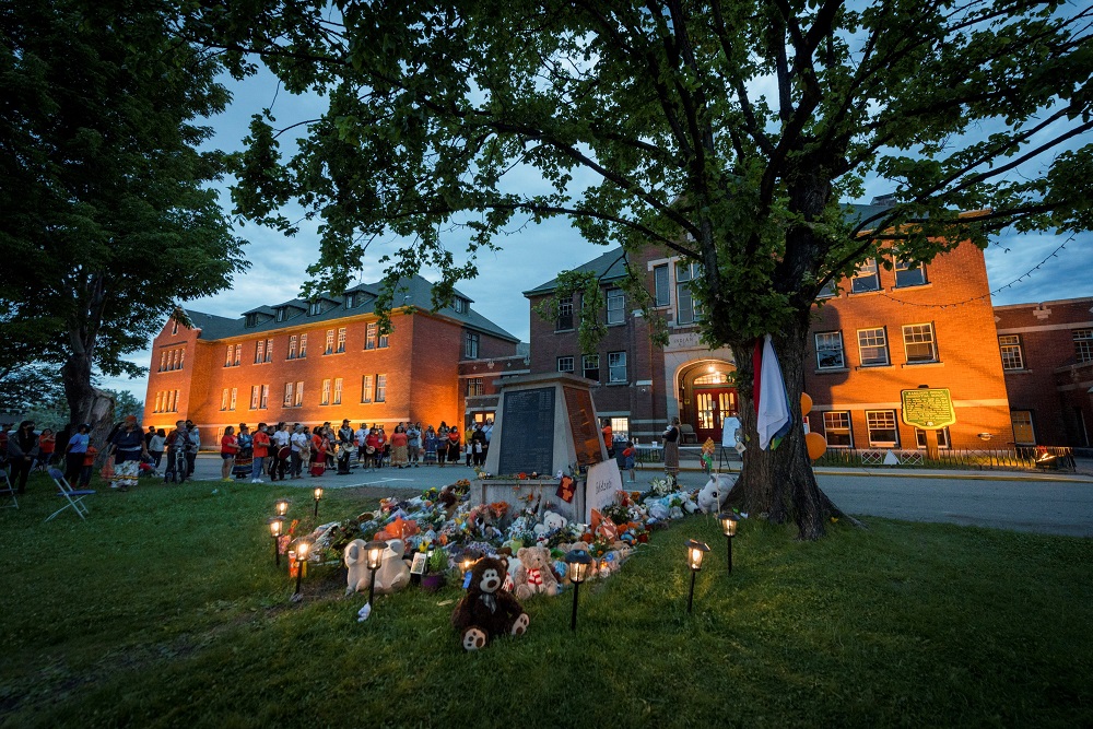 Kamloops residents and First Nations people gather to listen to drummers and singers at a May 31 memorial in front of the former Kamloops Indian Residential School in British Columbia. (CNS/Reuters/Dennis Owen)