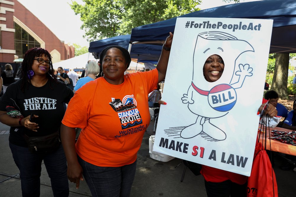 People in Atlanta advocate for the For the People Act on a June 21 stop on the Black Voters Matter organization's Freedom Ride for Voting Rights. Organizers said they planned the tour to recall the Freedom Rides, a series of protests against segregation b