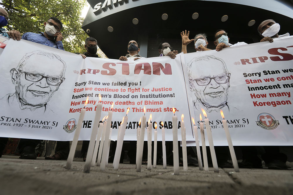 People hold a banner during a July 6 prayer service for Jesuit Fr. Stan Swamy in Mumbai, India, the day after he died at a hospital. (CNS/Reuters/Francis Mascarenhas)