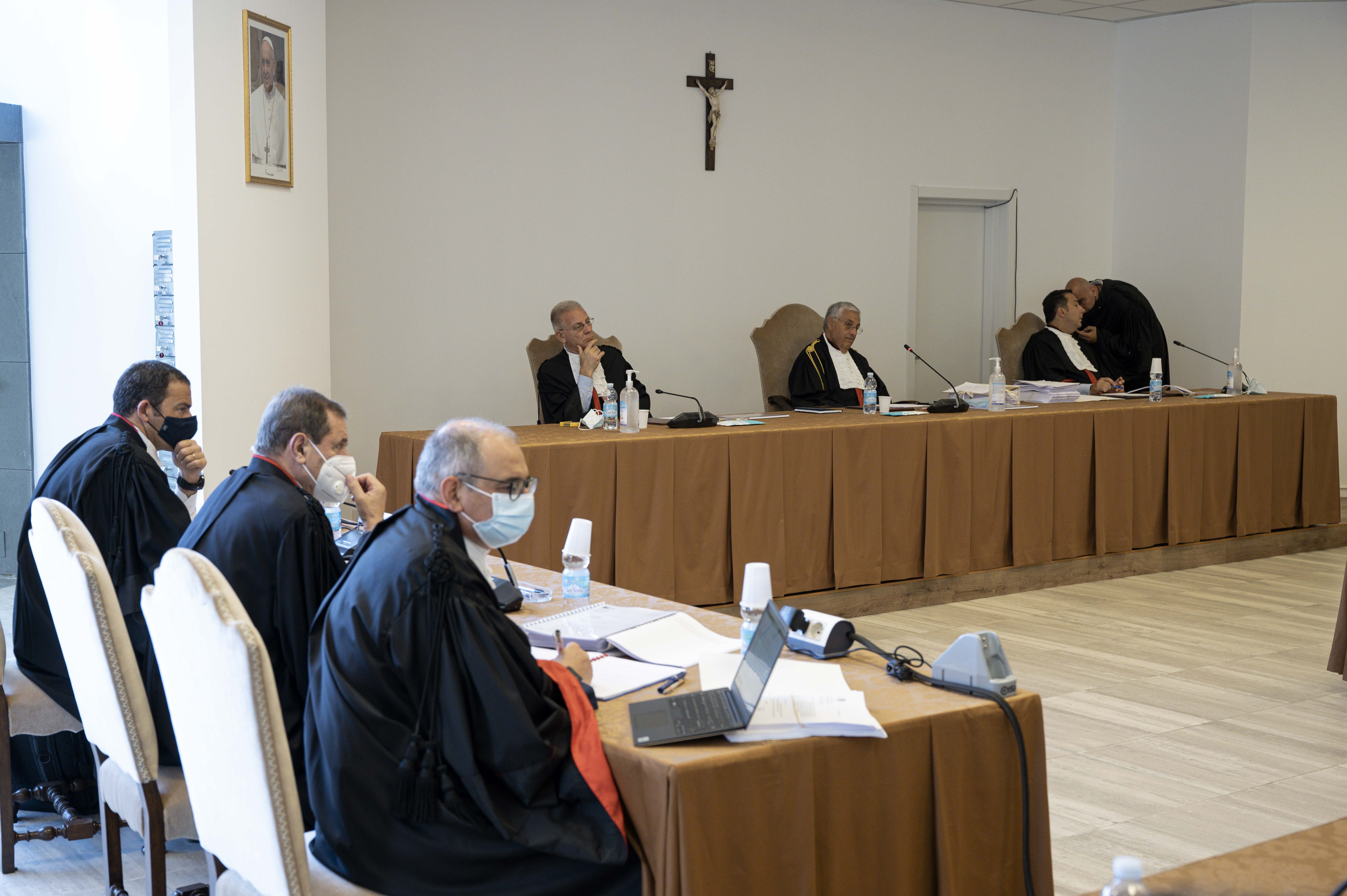 The judges of the Vatican City State criminal court -- Venerando Marano, Giuseppe Pignatone and Carlo Bonzano -- sit under a crucifix in a makeshift Vatican courtroom July 27, 2021, as the trial of 10 defendants in a financial malfeasance case begins. (CN