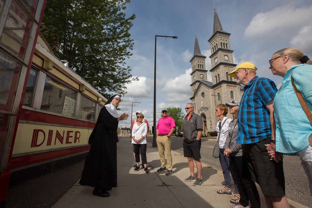 Actress Michelle Berg as Sister Celeste stands in front of the iconic Mickey's Diner restaurant July 8 in downtown St. Paul, Minnesota, as she talks about the history of the city to those taking one of her "True Confessions Gangster" tours.