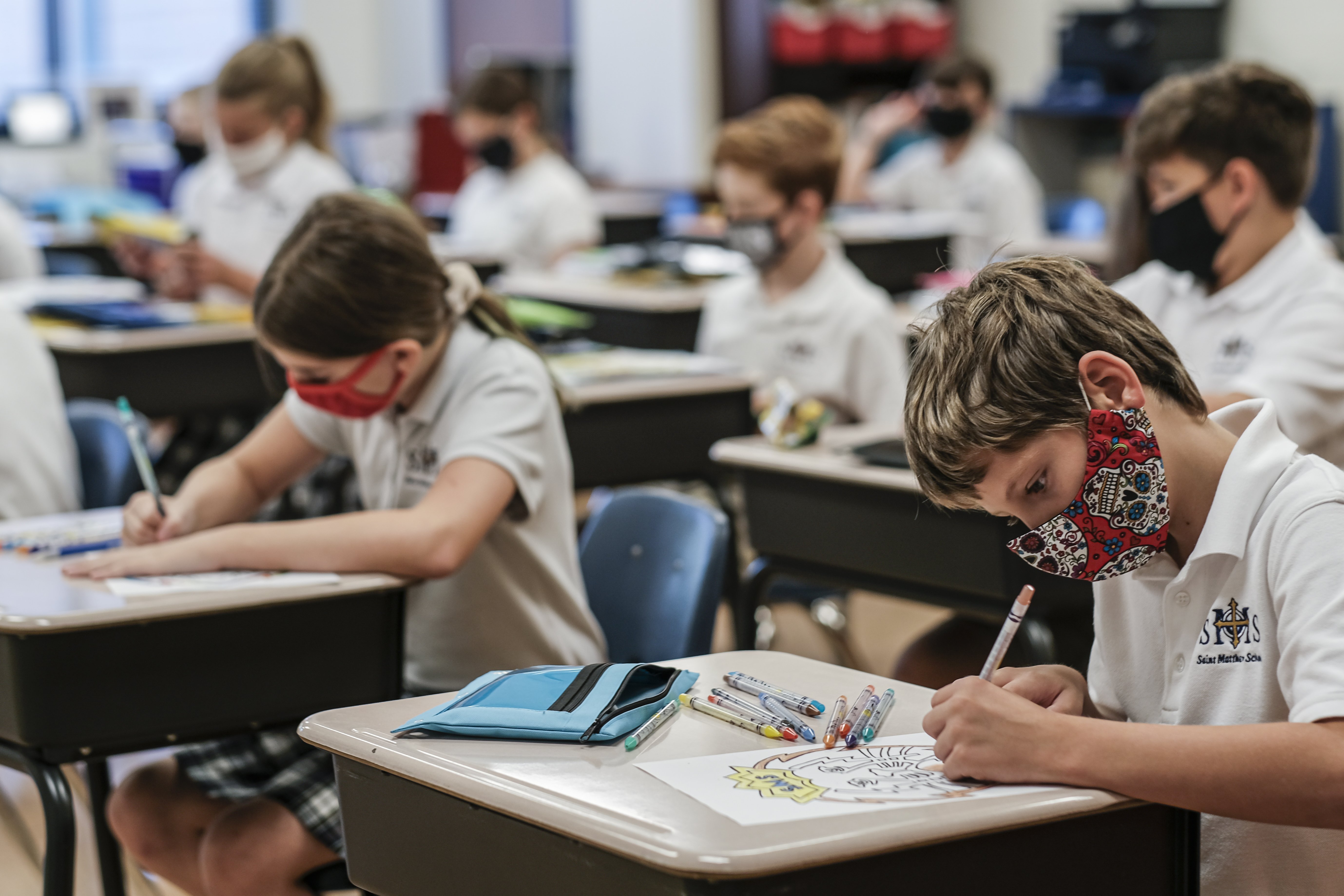 Students work at their desks on the first day of the new school year at St. Matthew School in Franklin, Tenn., Aug. 6, 2020, with extensive COVID-19 protocols in place, including temperature screening and mandatory face masks for each student. In Louisian