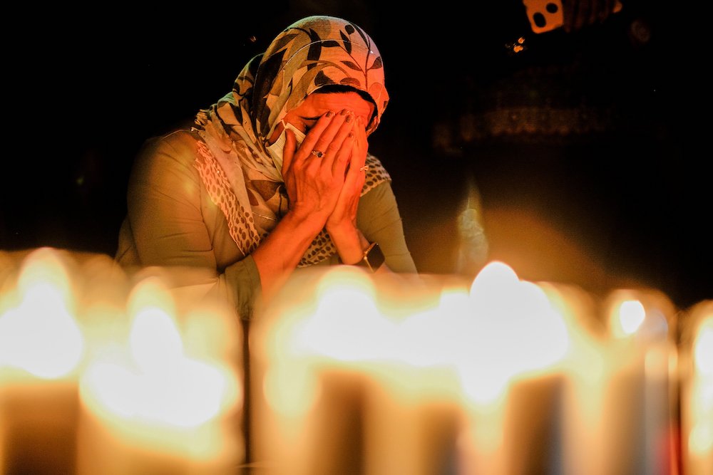 A woman in Los Angeles prays during a vigil for Afghanistan outside the West L.A. Federal Building Aug. 17. (CNS/Reuters/Ringo Chiu)