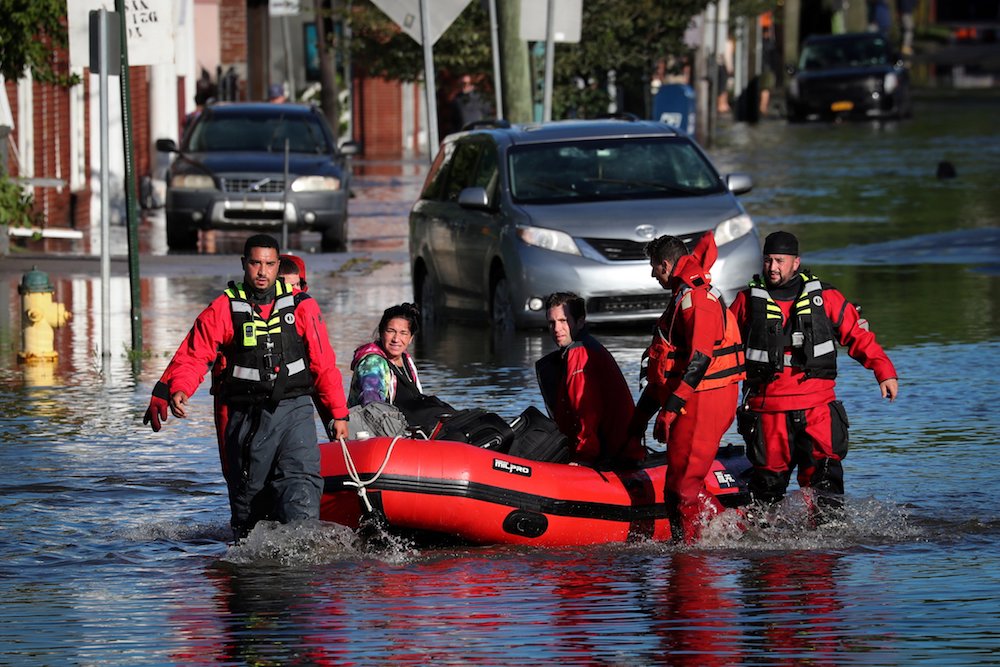 First responders in Mamaroneck, New York, pull local residents in a boat Sept. 2, as they rescue people trapped by floodwaters after the remnants of Tropical Storm Ida swept through the area. (CNS photo/Mike Segar, Reuters)