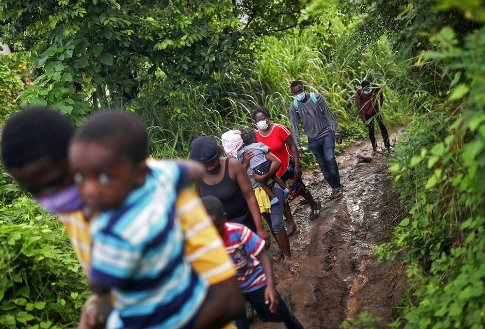 Haitian migrants walk through the forest in Tuxtla Chico, Mexico, Sept. 16 as part of a group of thousands of migrants who were heading to the U.S. border. (CNS/Reuters/Edgard Garrido)