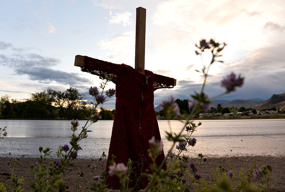 A child's red dress hangs on a cross near the grounds of the former Kamloops Indian Residential School in Kamloops, British Columbia, June 5, 2021. (CNS)