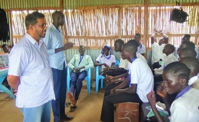 Man teaches a group of students sitting in chairs 