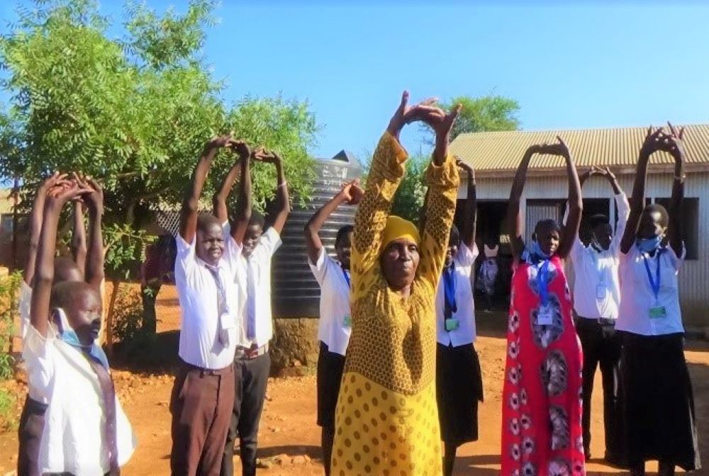 people standing in a line stretching their arms to the sky