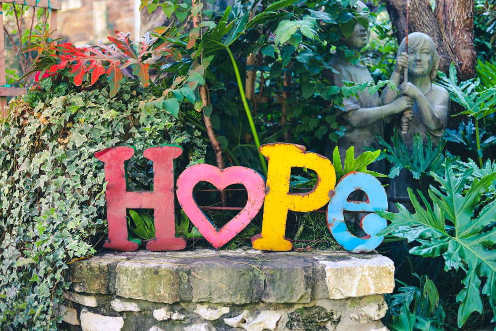cutout letters in a garden spell "HOPE"