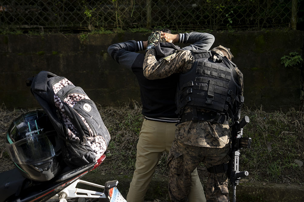 An army soldier frisks a motorcyclist at a checkpoint outside Comasagua, El Salvador, Oct. 6. (AP/Moises Castillo)