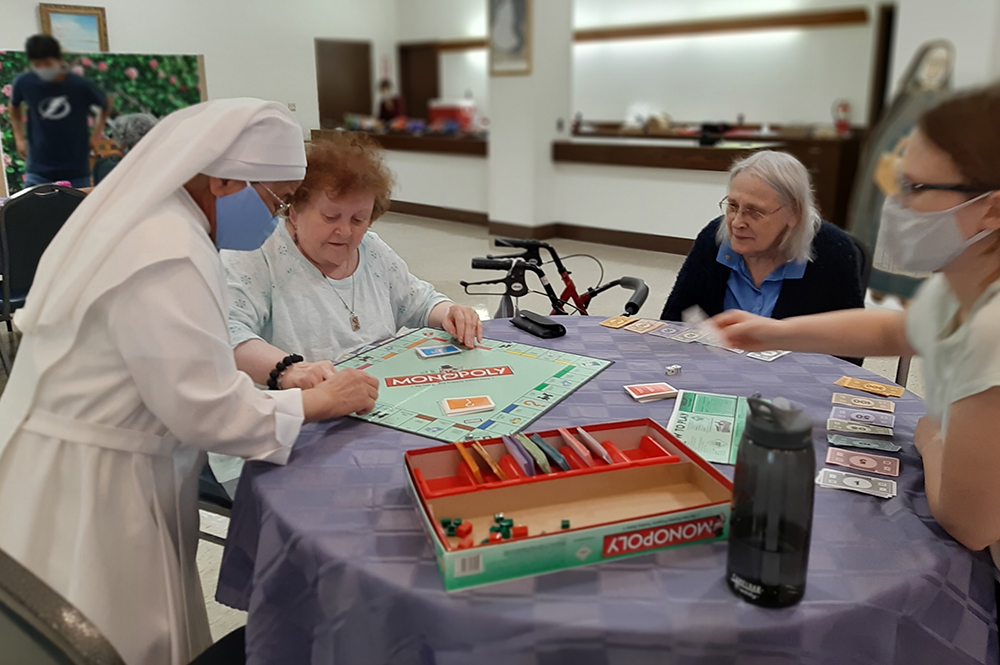 A Little Sister of the Poor plays Monopoly with residents in Washington in 2021. (Courtesy of the Little Sisters of the Poor)