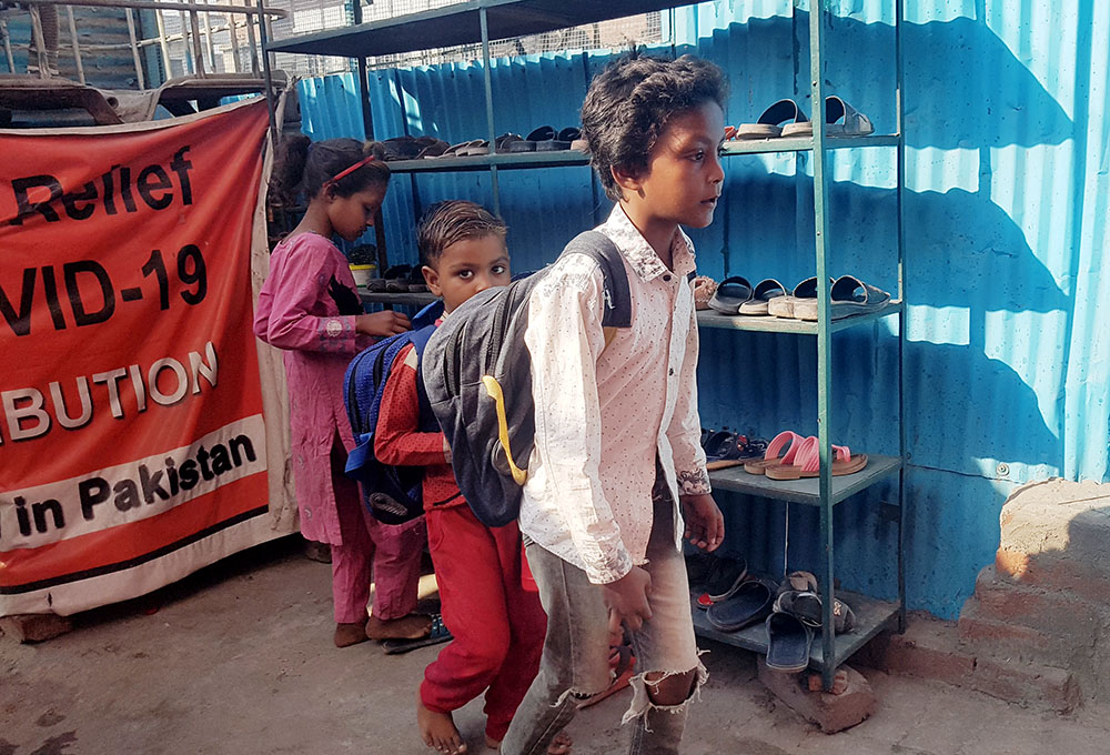 Gypsy children remove their shoes to attend Sunday school at Soar Primary School, managed by a Sister of St. Joseph associate in Lahore, Pakistan. (GSR photo/Kamran Chaudhry)