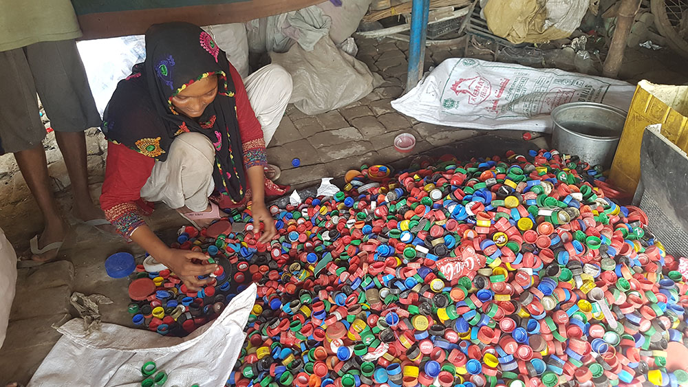 Nazia Manzoor sorts bottle caps with matching colors in the Gypsy colony in China Scheme of Lahore, Pakistan. (GSR photo/Kamran Chaudhry)