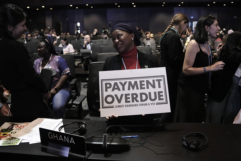 In a call for compensation on climate loss and damage, Nakeeyat Dramani Sam of Ghana holds a sign that reads "payment overdue" Nov. 18 at COP27 in Sharm el-Sheikh, Egypt. (AP/Nariman El-Mofty)