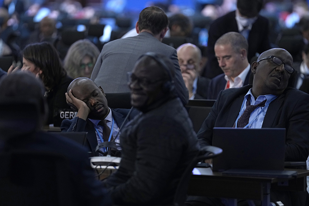 Delegates rest during a break in a closing plenary session at COP27 in Sharm el-Sheikh, Egypt, on Nov. 20, two days after the climate summit's scheduled conclusion. (AP/Peter Dejong)