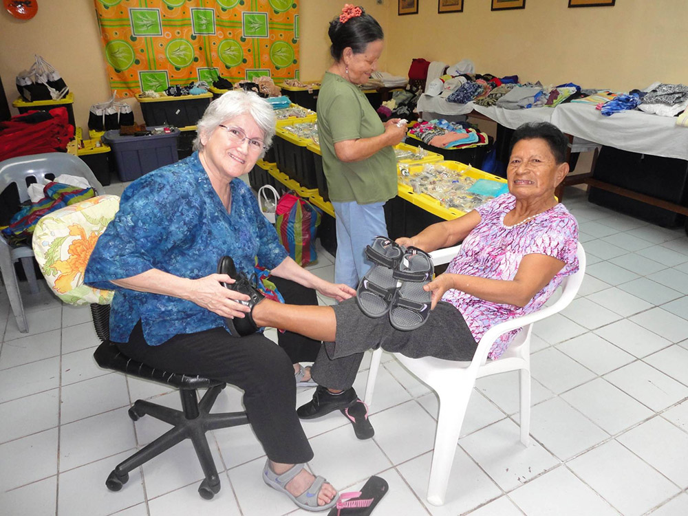 Sr. Annie Credidio helps a patient try on shoes at Damien House in Guayaquil, Ecuador, which treats people with leprosy. Credidio won $100,000 as a finalist for the 2022 Opus Prize. (Courtesy of Damien House)