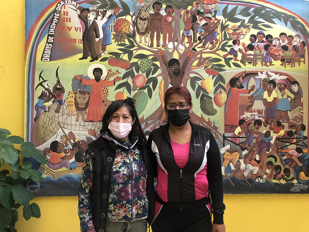 Maitena, a la izquierda, y Lorena, dos participantes habituales en los programas de la Casa Madre Antonia, delante del mural de la entrada de la Casa.