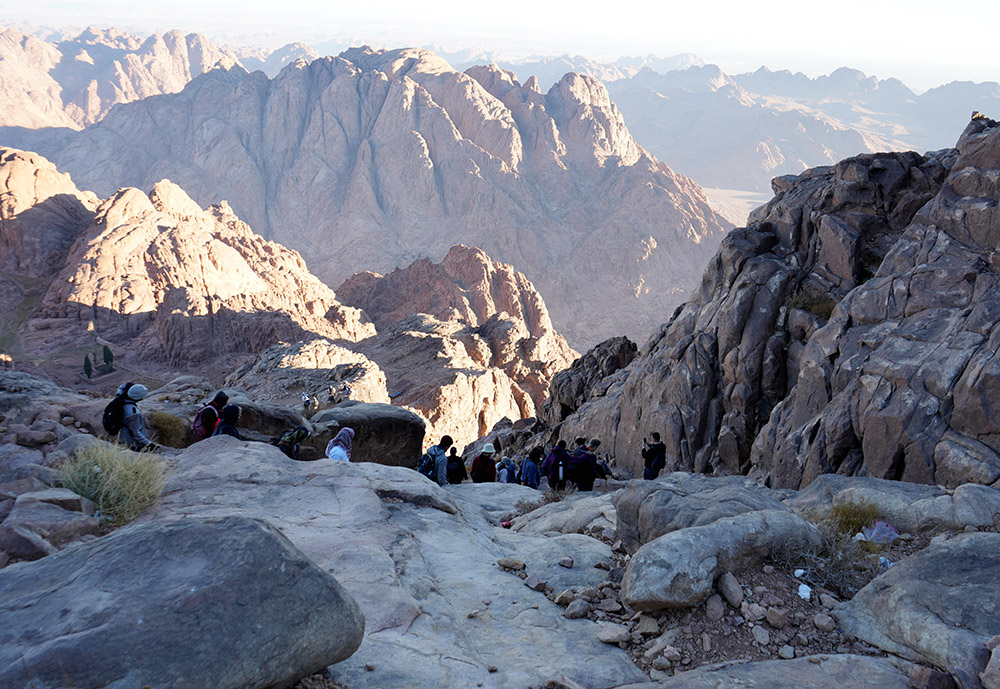 Religious actors and climate activists climb down Mount Sinai after watching the sunrise Nov. 14. At the foot of the mountain, they prayed to God to intervene and save the world from climate change. (EarthBeat photo/Doreen Ajiambo)