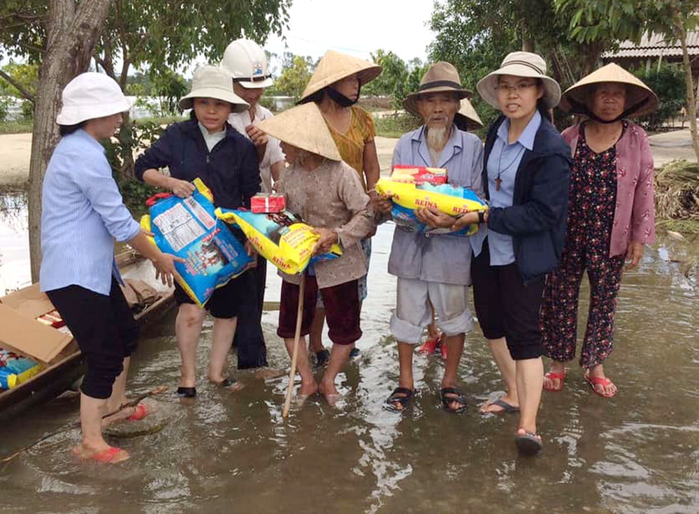 Nguyen Chac (third from right) receives food from Lovers of the Holy Cross of Hue, Vietnam, Oct. 3. (GSR photo/Joachim Pham)