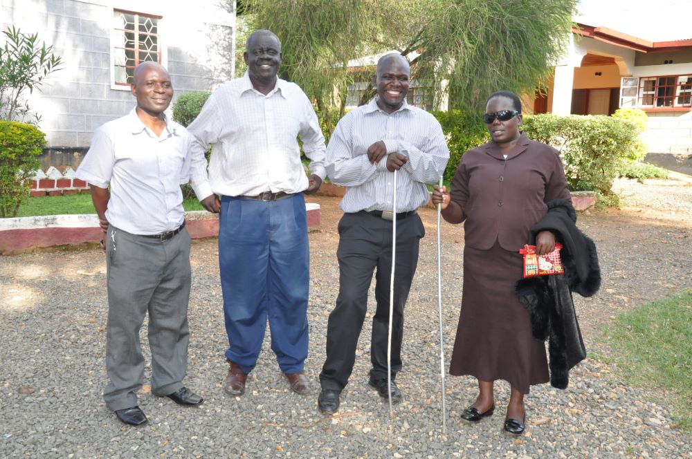 4 people, all former students who are now teachers, pose in a line.