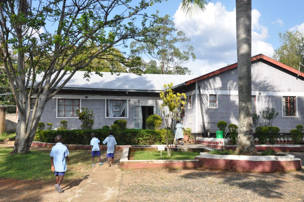 Pupils walk around yard with gray and white building