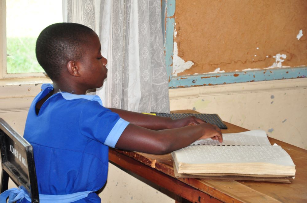 Student uses Braille to read book