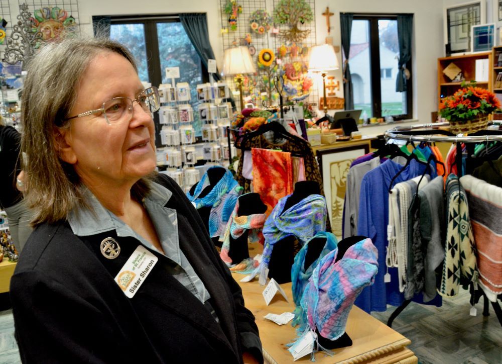 Sylvania Franciscan Sr. Sharon Havelak, one of the sisters who founded the congregation's gift shop in Sylvania, Ohio, stands near hand-painted silk scarves the shop sells. (GSR photo/Dan Stockman)