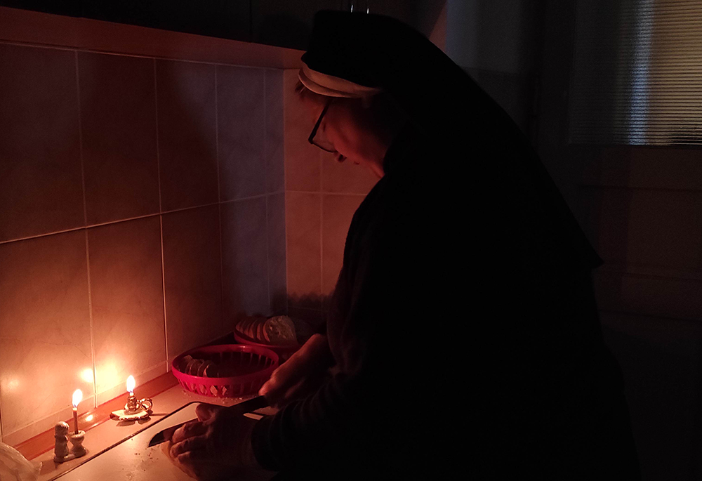 A Basilian sister prepares food by candlelight in Ukraine. As Basilian Sr. Yeremiya Steblyna writes, "The Ukrainian people have entered a time of blackout." (Courtesy of Yeremiya Steblyna)