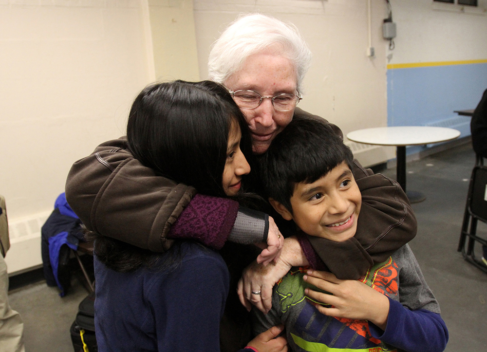 Sr. Margaret Smyth hugs two children