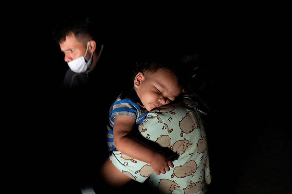 A migrant child from Central America sleeps on his mother's shoulder in Roma, Texas, July 28, 2021, after they crossed the Rio Grande into the United States from Mexico seeking asylum. (CNS/Reuters/Go Nakamura)