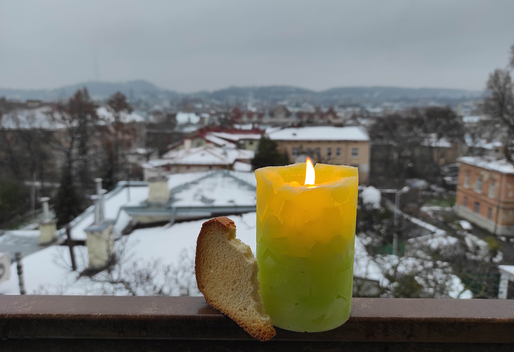 A memorial candle and a slice of bread are pictured Nov. 26 in Ukraine. Basilian Sr. Yeremiya Steblyna placed the candle and bread in her window on the Day of Remembrance for the Holodomor Victims, as a sign that "even with fields of wheat, my nation was starving in the 1933 famine in Ukraine." (Courtesy of Yeremiya Steblyna)