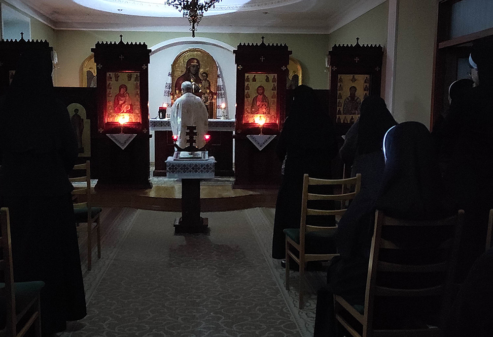 In Ukraine, Basilian sisters pray at Mass, lit by candles. (Courtesy of Yeremiya Steblyna)
